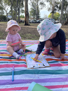 Two participants drawing a map on a mat outside